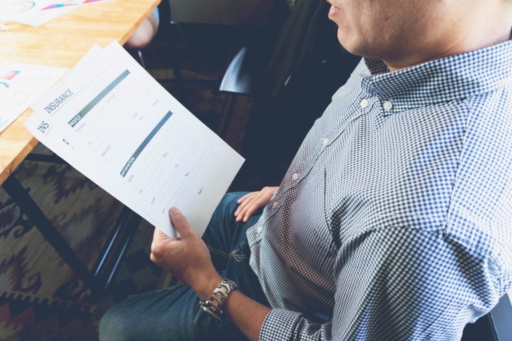 Man looks at his insurance paper work with stress