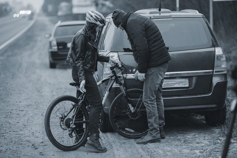 cyclist and motorist exchange insurance information after a collision
