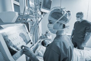 Surgeon checks Patient vitals on medical equipment. 