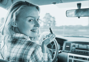 Distracted driver putting on makeup while behind the wheel of the car.